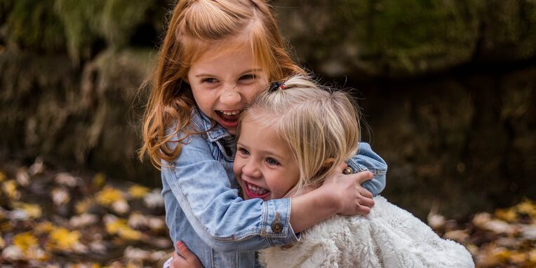 zwei kleine Mädchen umarmen sich
