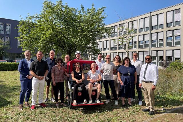 Gruppenfoto vor der Rikscha vor dem Rathaus