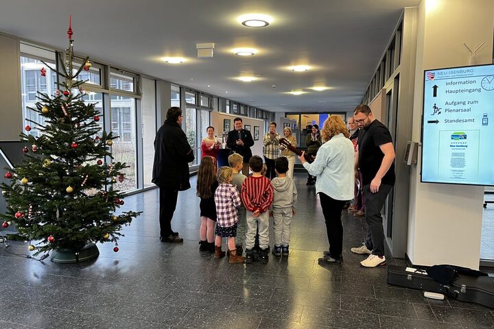 Kinder von hinten im Foyer des Rathauses mit einem Weihnachtsbaum