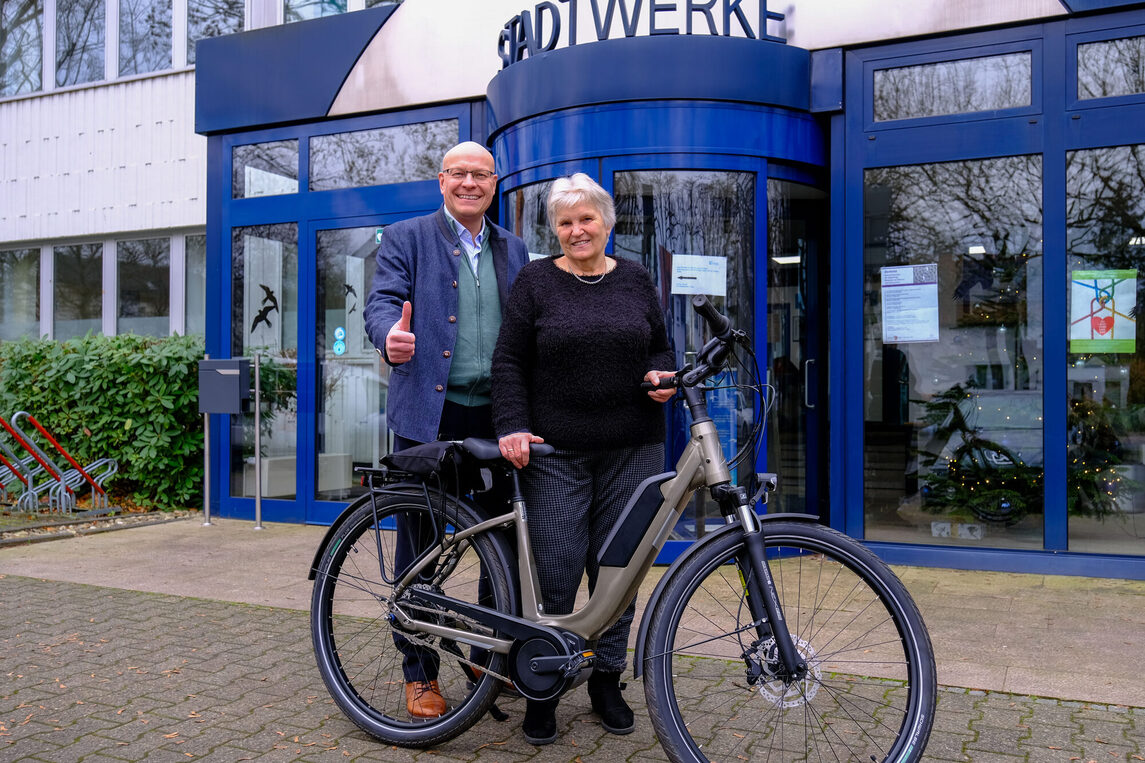 Freude über den Hauptgewinn: Margit Schüttler (rechts) nimmt strahlend ihr neues E-Bike von Kirk Reineke, Geschäftsführer der Stadtwerke Neu-Isenburg, entgegen.