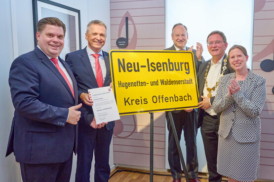 Vlnr: Erster Stadtrat Stefan Schmitt, Staatssekretär Martin Rößler, Landrat Oliver Quilling, Bürgermeister Dirk Gene Hagelstein, Stadtverordnetenvorsteherin Christine Wagner bei der feierlichen Enthüllung des neuen Ortsschildes mit der Zusatzbezeichnung