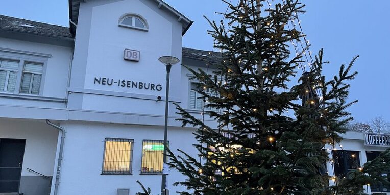 Weihnachtsbaum mit Lichterkette vor dem Bahnhofsgebäude in Neu-Isenburg