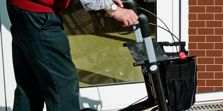Eine männliche Person mit einem Rollator