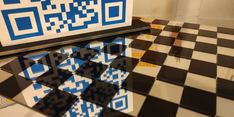 Ein QR-Code spielgelt sich auf Boden