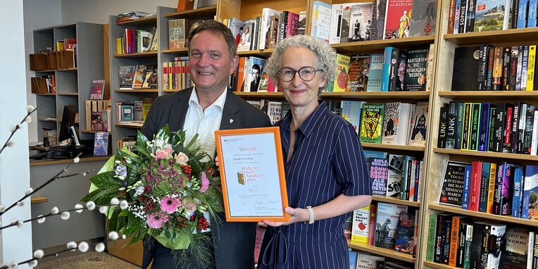 vlnr Bürgermeister Dirk Gene Hagelstein und Anja Kronier in der Buchhandlung