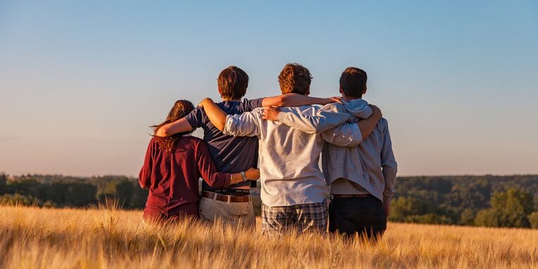 Eine Gruppe sitzender junger Leute mit Blick in die Ferne