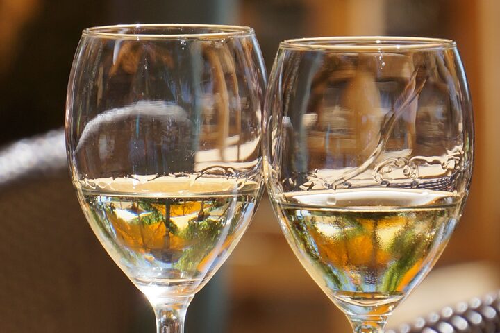 2 Weingläser halb gefüllt mit Wein auf einem Holztisch