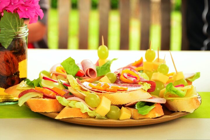 Ein Teller mit belegten Broten, Käse und Weintrauben