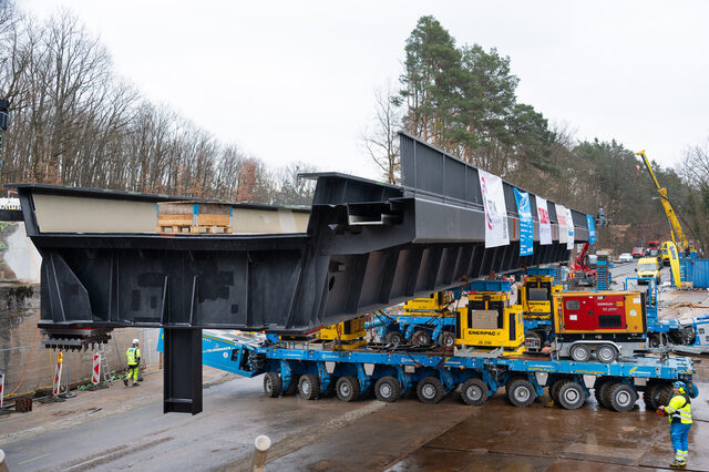 In Bewegung: Ein Self Propelled Modular Trailer (SPMT) fährt die 250 Tonnen schwere Brücke in Richtung Einbauposition.