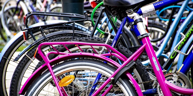 verschieden farbige Fahrräder an einem Fahrradständer