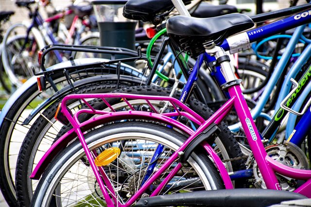 verschieden farbige Fahrräder an einem Fahrradständer