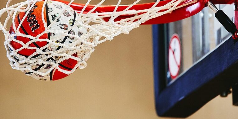 Basketballnetz mit einem orange-weißem Basketball