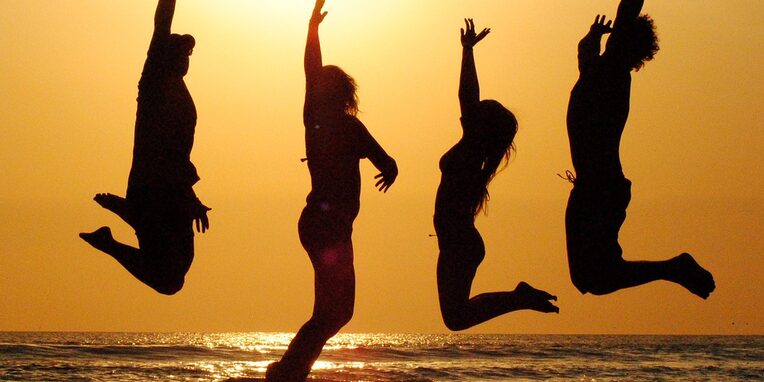 Menschen hüpfend am Strand