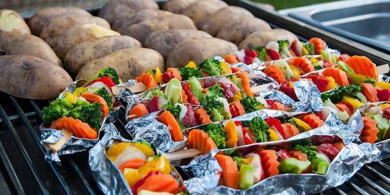 Kartoffeln und Gemüsespieße auf einem Grill