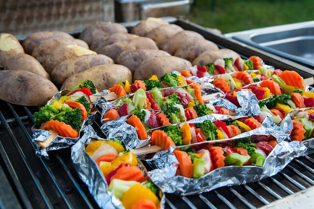 Kartoffeln und Gemüsespieße auf einem Grill