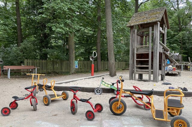 Außenbereich der KITA in Zeppelinheim mit ihrem "kleinen Fuhrpark"