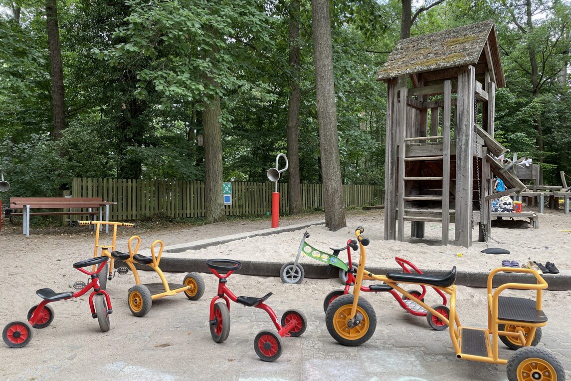 Außenbereich der KITA in Zeppelinheim mit ihrem "kleinen Fuhrpark"